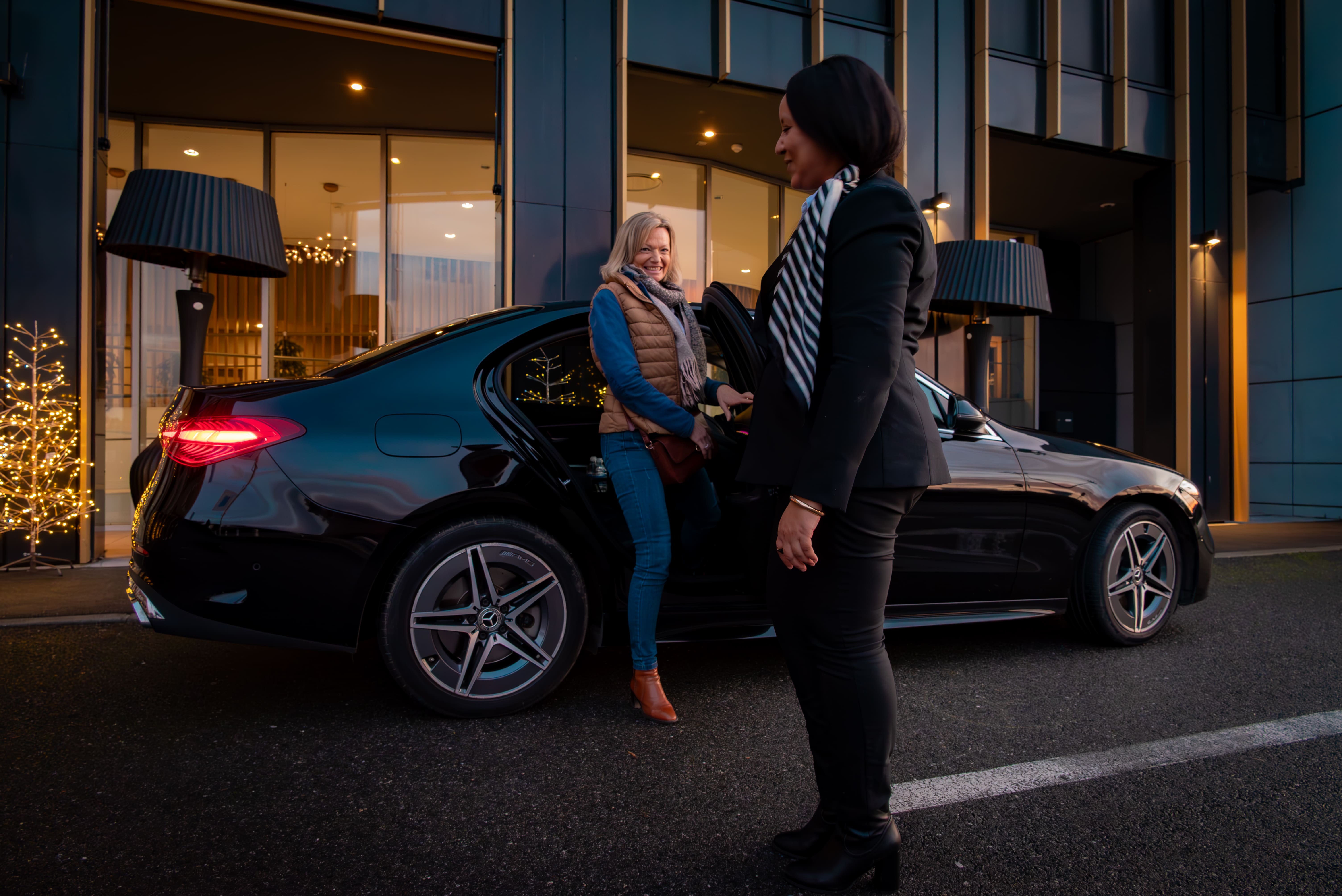 Houda AZZOUNI accueillant une cliente devant sa Mercedes